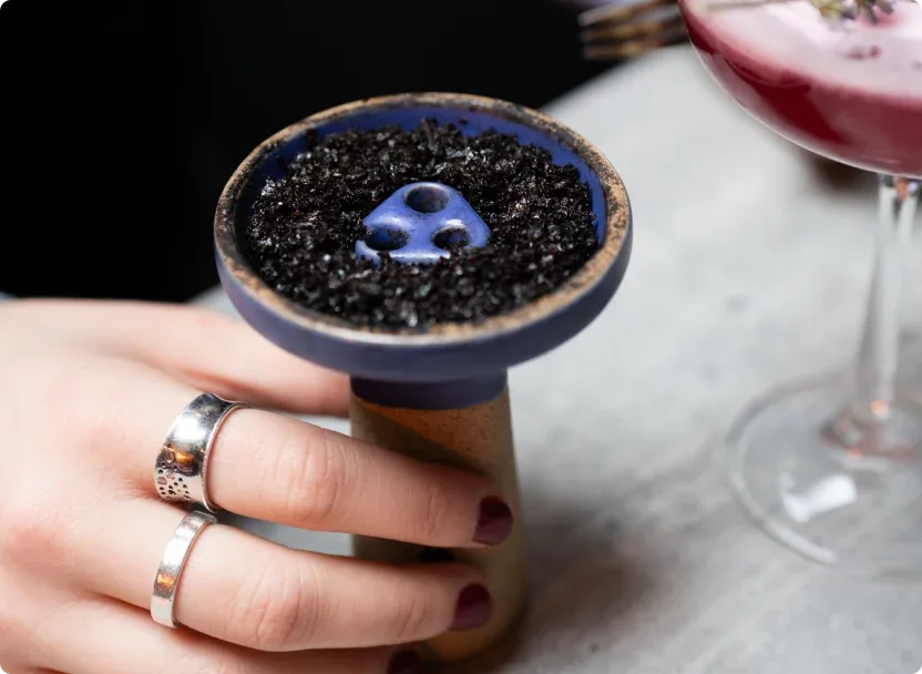 Shisha bowl prepared beside a cocktail at Laika Shisha Lounge in Soho