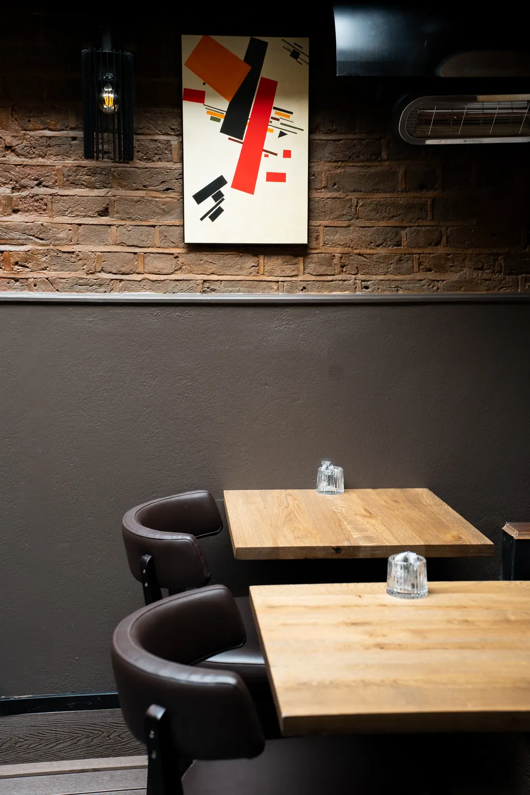 Corner tables under warm wall light at Laika Soho